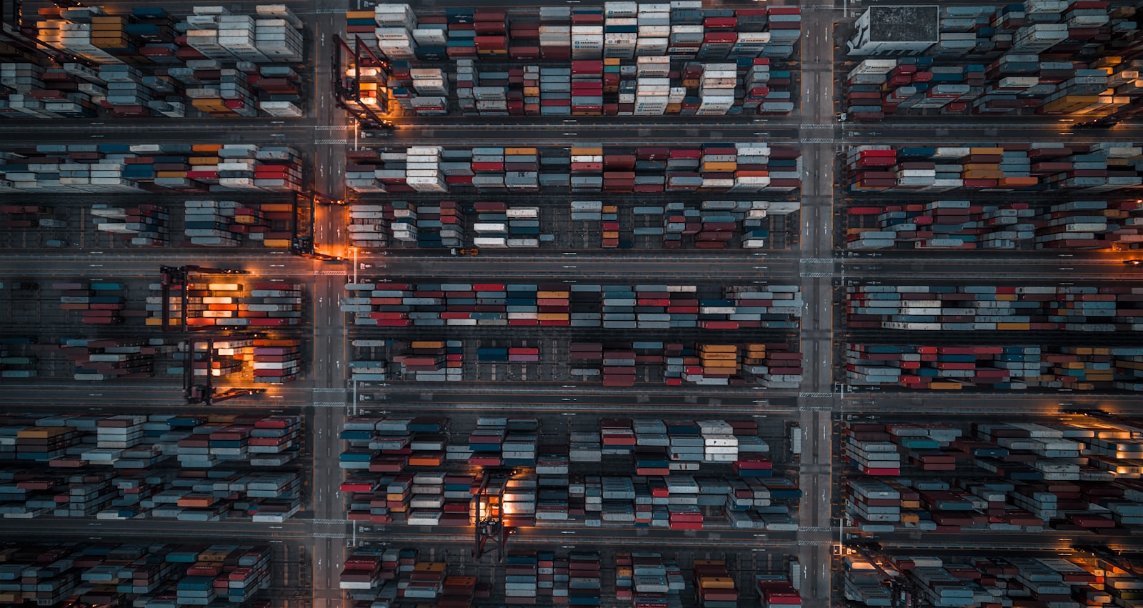 Luftaufnahme eines Container- und Fuhrparklagers bei Nacht